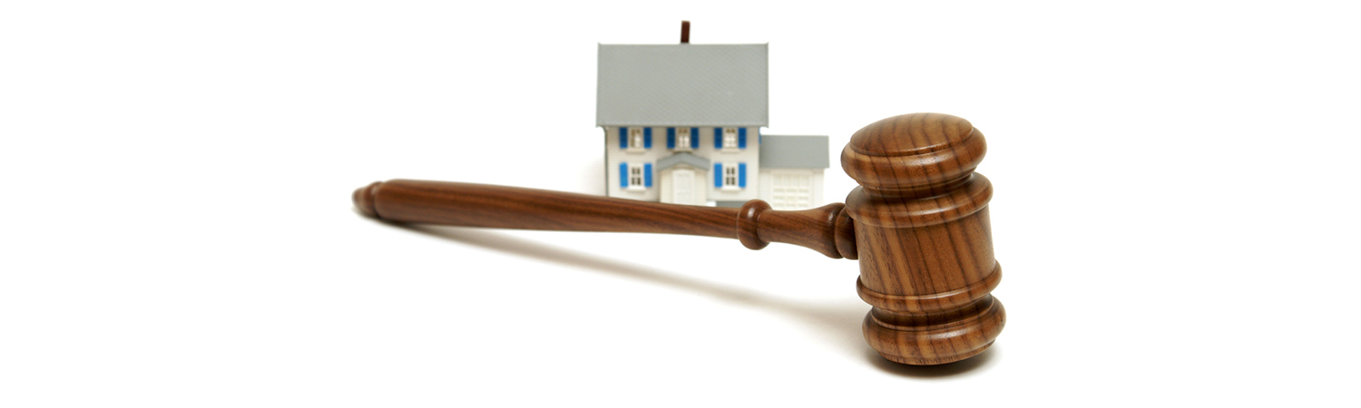Gavel Foreground with Model House in Background